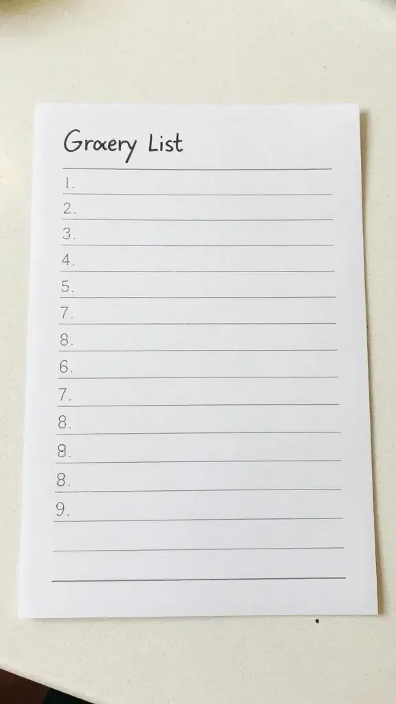 Closeup of a single labeled grocery list on a clean kitchen countertop